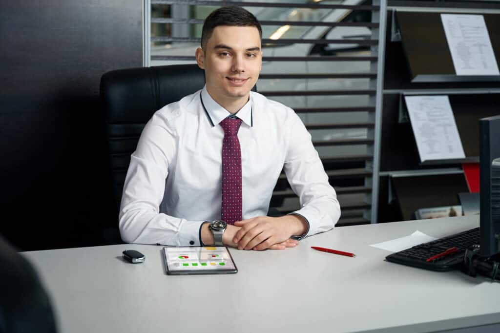 Young dealership general manager viewing Dealersink inventory management reports on his tablet